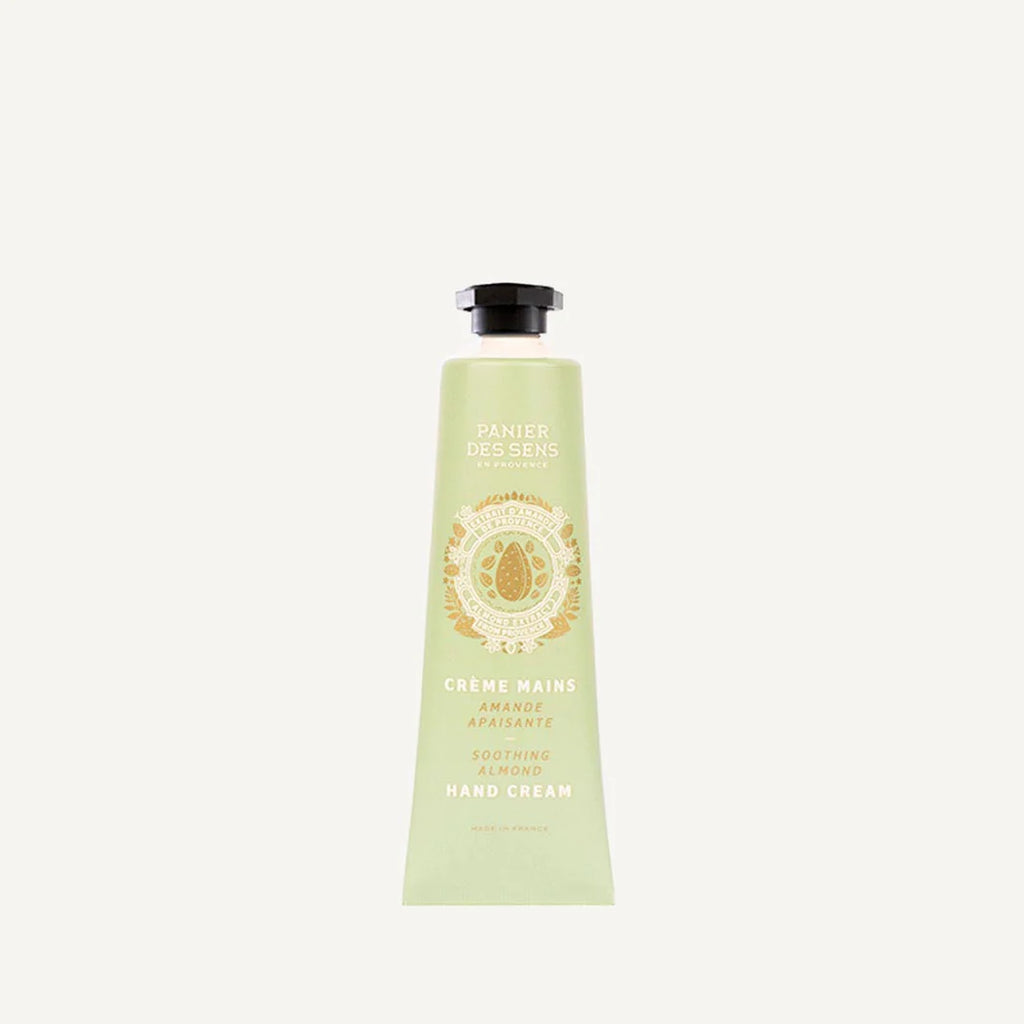 A light green squeeze tube of Panier Des Cens Creme Mains Hand Cream, featuring a black cap and gold lettering, centered on a light off-white background.