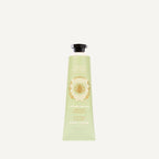 A light green squeeze tube of Panier Des Cens Creme Mains Hand Cream, featuring a black cap and gold lettering, centered on a light off-white background.