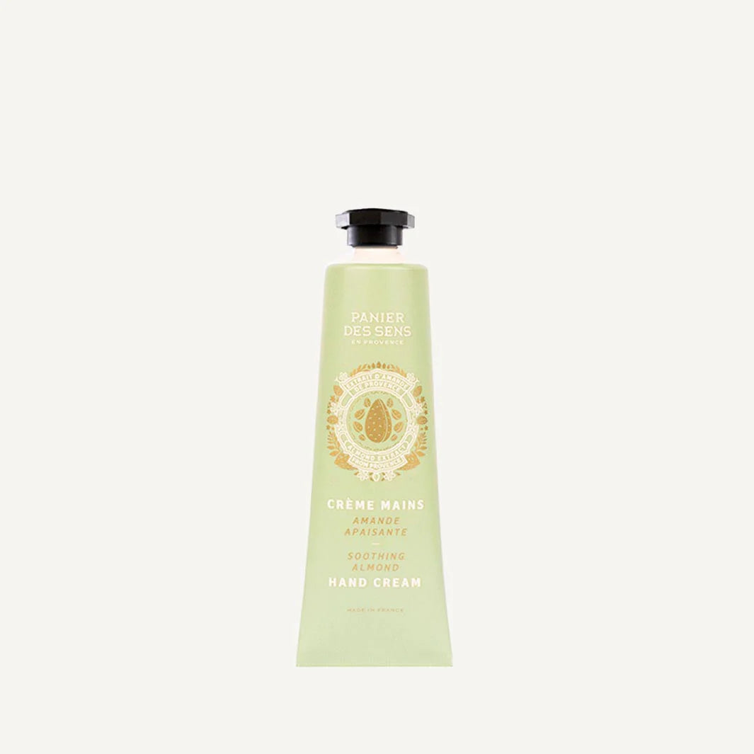 A light green squeeze tube of Panier Des Cens Creme Mains Hand Cream, featuring a black cap and gold lettering, centered on a light off-white background.