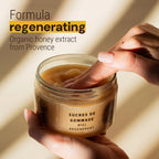 Jar of organic honey extract with a hand scooping out the product, set against a warm background.