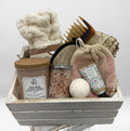 Bath and body gift set with various items in a wooden basket on a white background