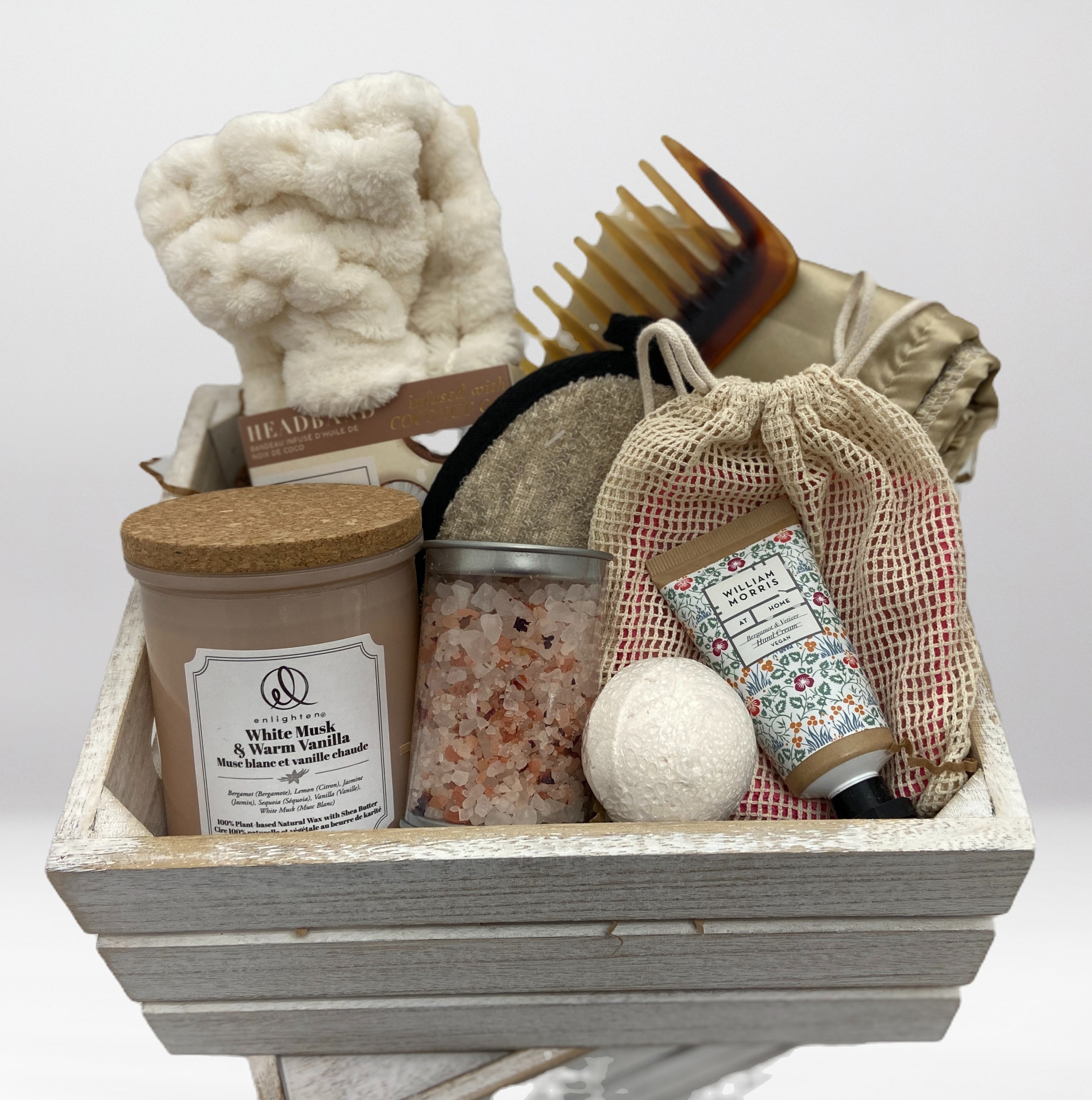 Bath and body gift set with various items in a wooden basket on a white background