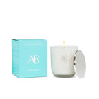 White candle with lid and teal box featuring 'AB' logo on a white background