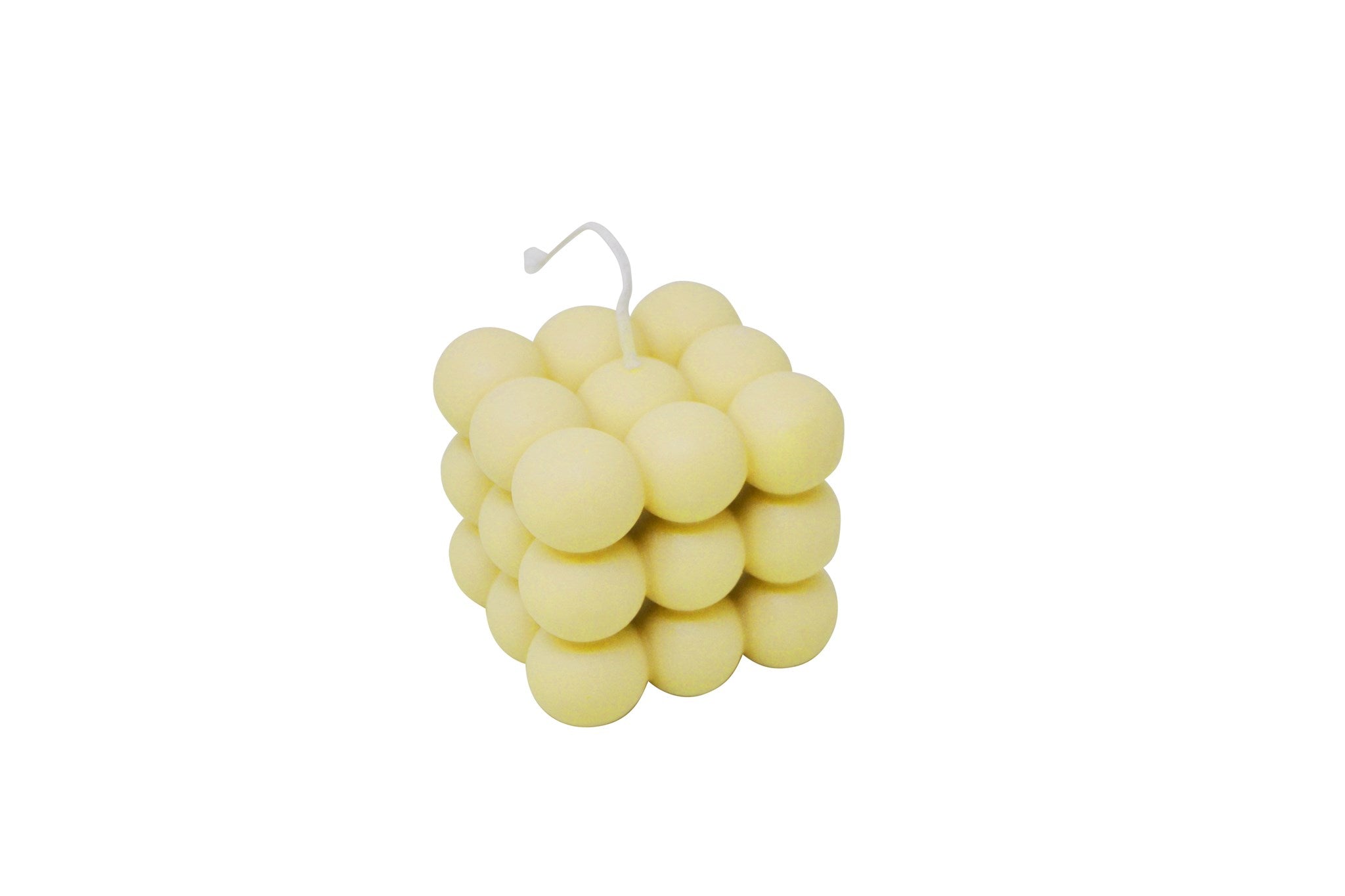 A pale yellow cube-shaped candle made of clustered round spheres, with a thin white wick at the top, shown on a plain white background.