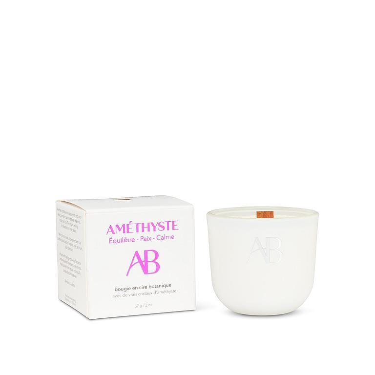 White candle with 'AB' branding next to its packaging on a white background