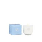 White candle with 'AB' logo next to a blue box on a white background