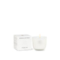 White candle with a visible brand logo next to its packaging on a white background