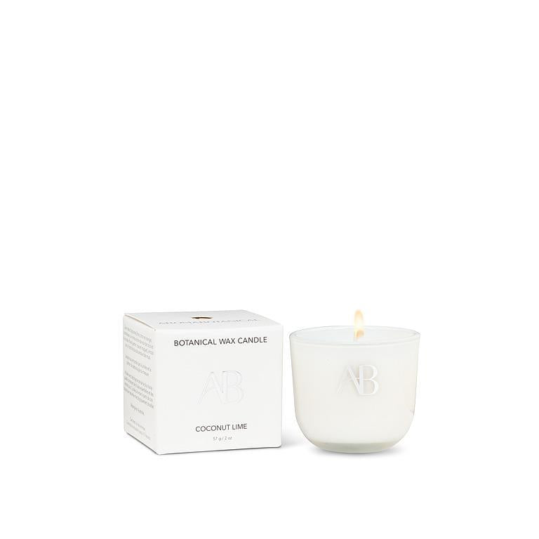 White candle with a visible brand logo next to its packaging on a white background