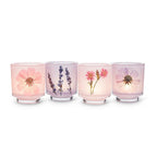 Four glass candle holders with floral designs on a white background