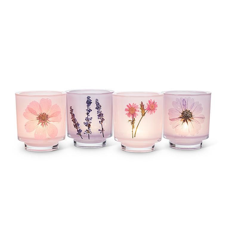 Four glass candle holders with floral designs on a white background
