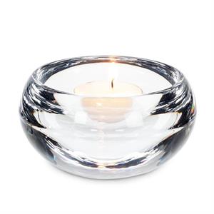 Clear glass candle holder with a lit candle on a white background