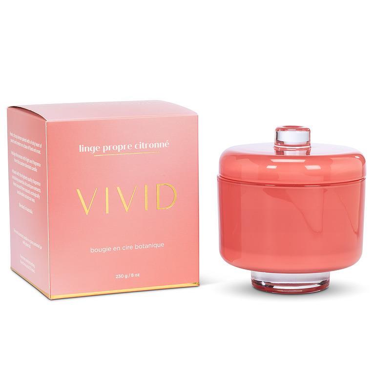 Coral-colored candle with a matching box on a white background