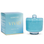 Blue candle in a glass jar with a matching box labeled 'VIVID' on a white background