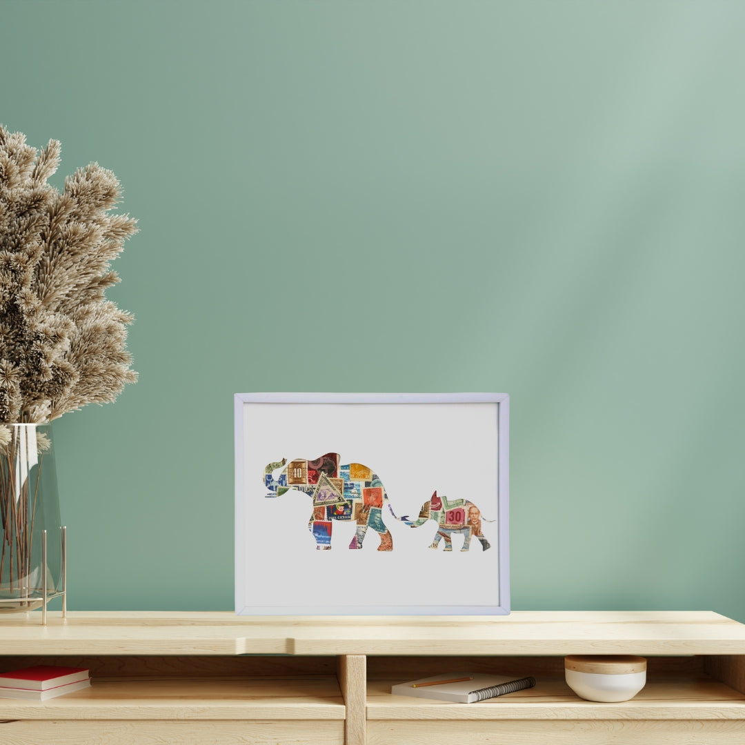 Framed artwork of two elephants on a shelf against a green wall