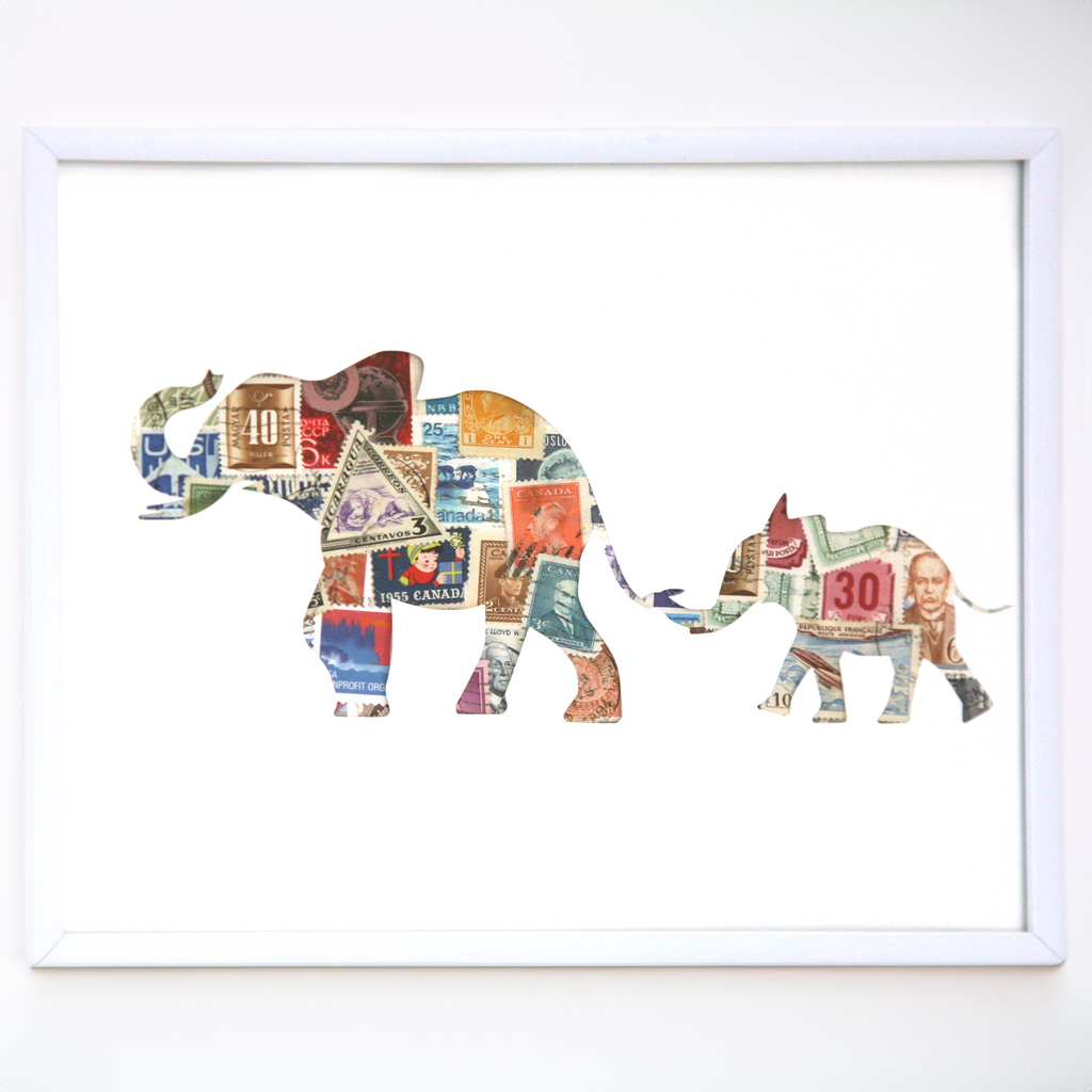Framed artwork of two elephants made from colorful paper with a white background