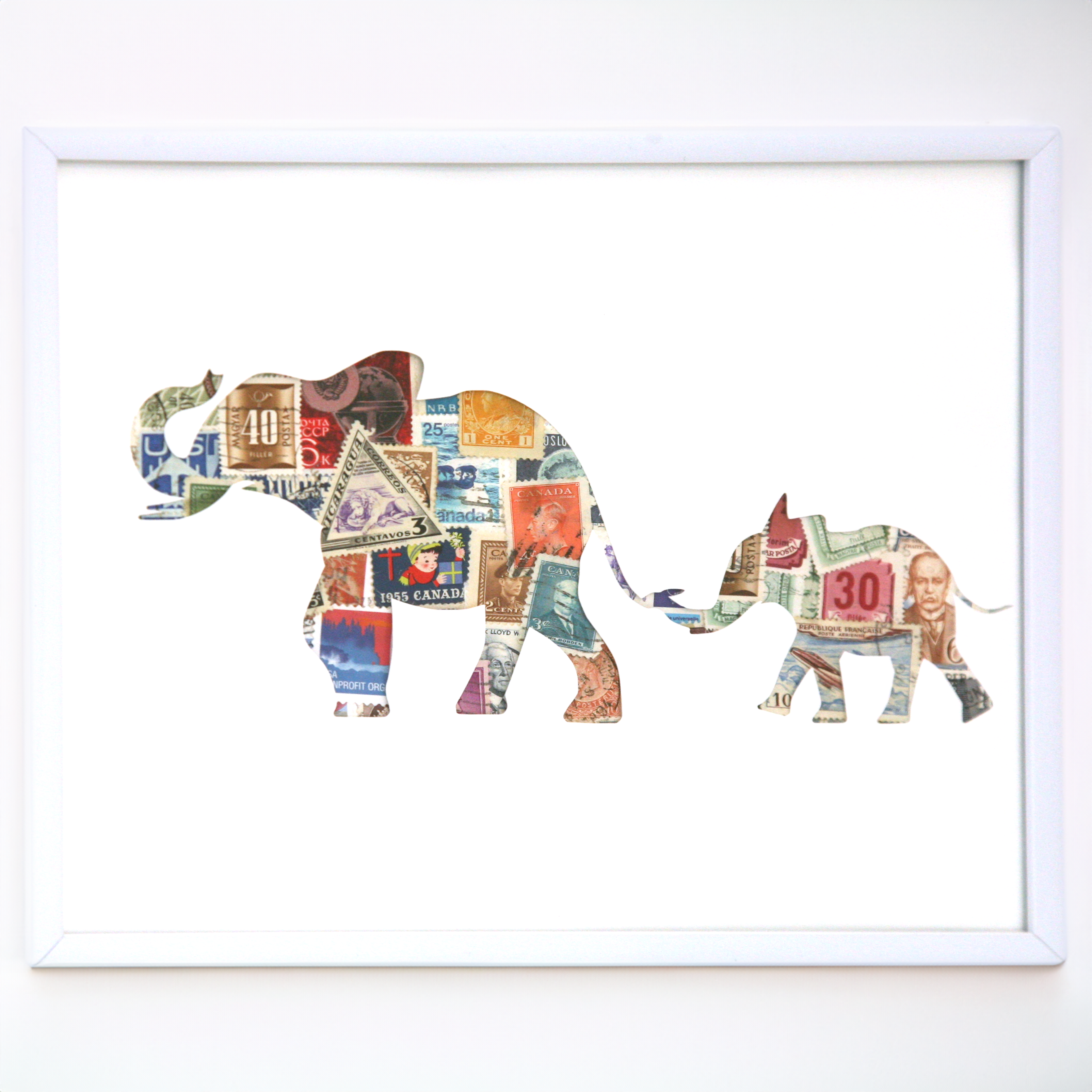 Framed artwork of two elephants made from colorful paper with a white background