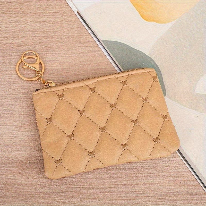Beige quilted pouch with gold zipper on a textured surface