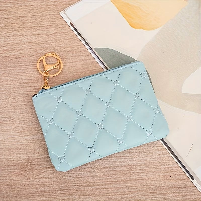 Light blue quilted pouch with gold keychain on a wooden surface