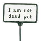 Metal sign with 'I am not dead yet' text on a white background