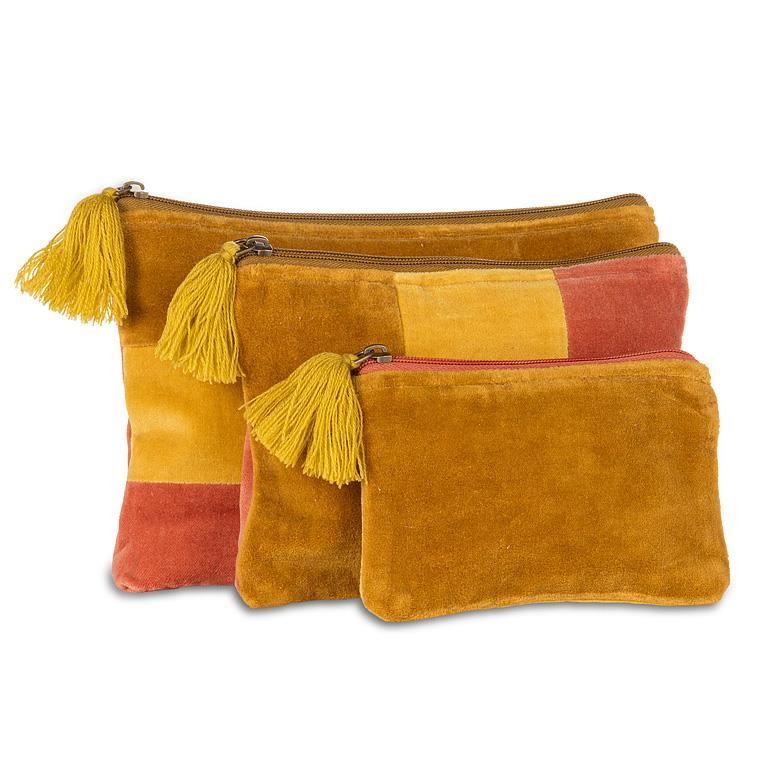 Three suede zippered pouches in a nested set, featuring a color-blocked design in mustard yellow, orange, and red, with matching yellow tassels on the zipper pulls, set against a plain white background.