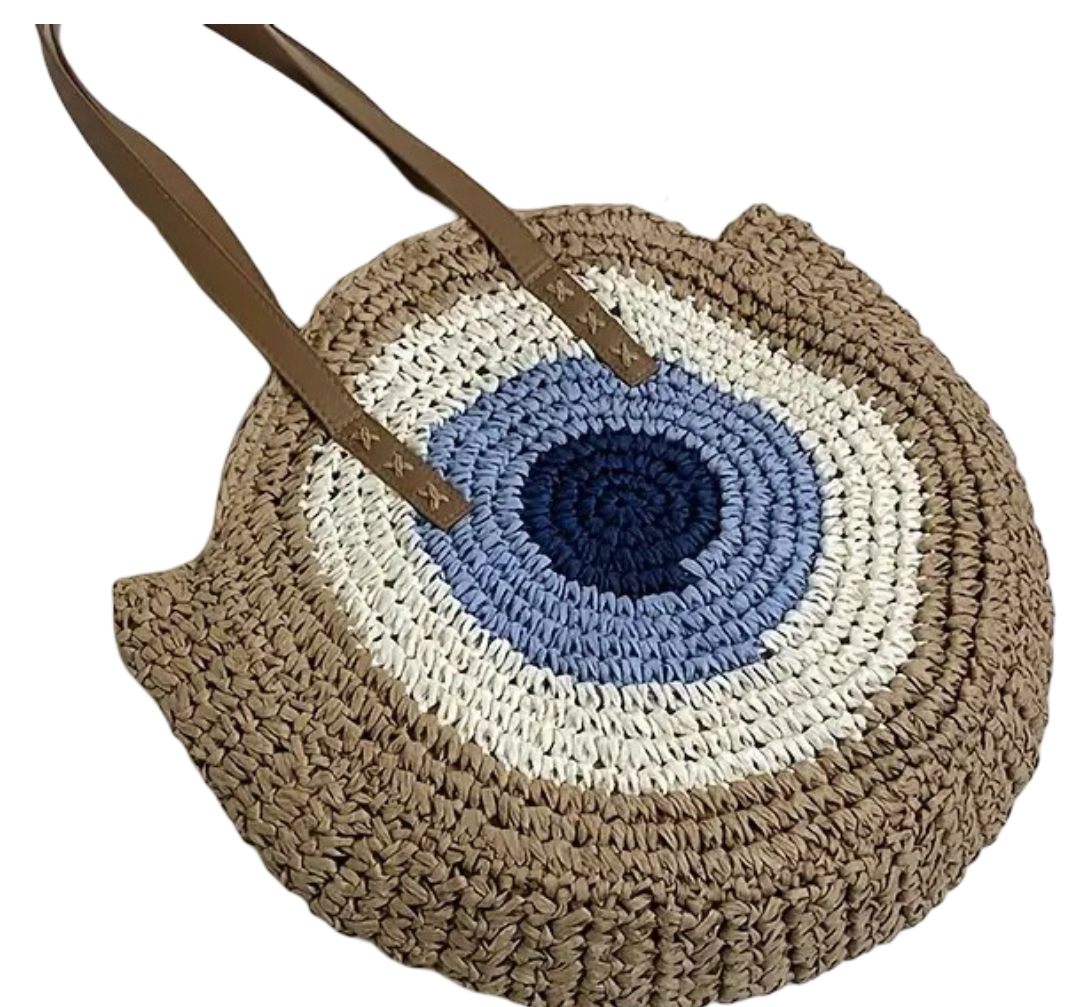 Round woven bag with a blue and white center and brown handle on a white background