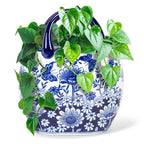 Blue and white floral-patterned planter with green vines on a white background