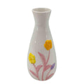 White vase with yellow flowers and pink leaves on a white background