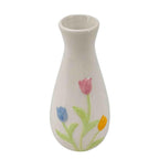 White ceramic vase with colorful floral designs on a white background