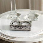 Silver candle holder on a white surface with a blurred background