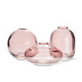 Three pink glass vases of different shapes on a white background