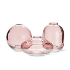 Three pink glass vases of different shapes on a white background