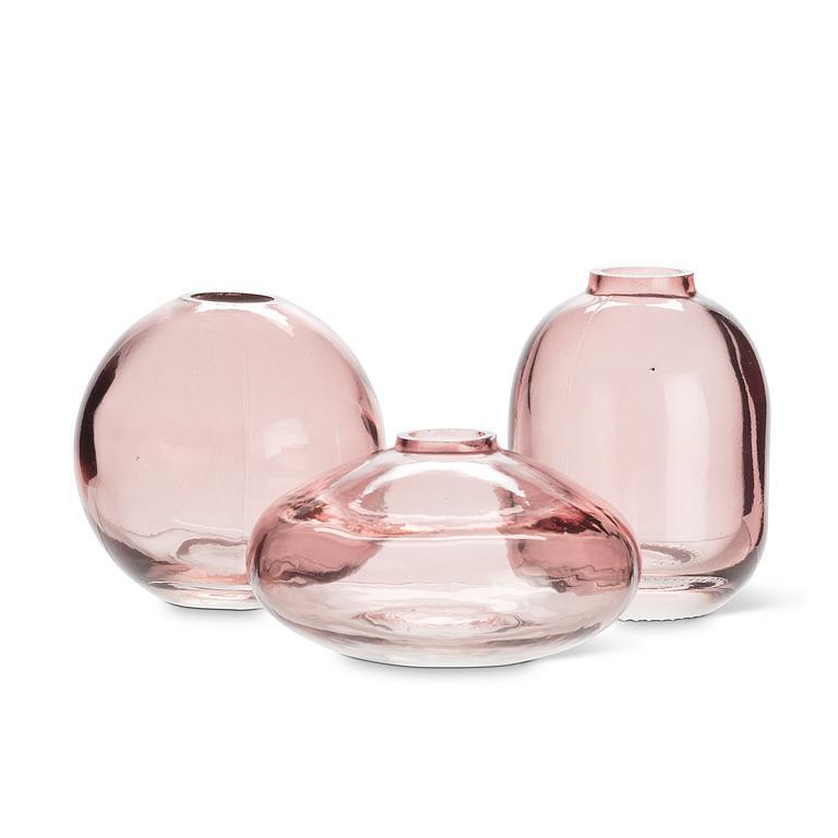Three pink glass vases of different shapes on a white background