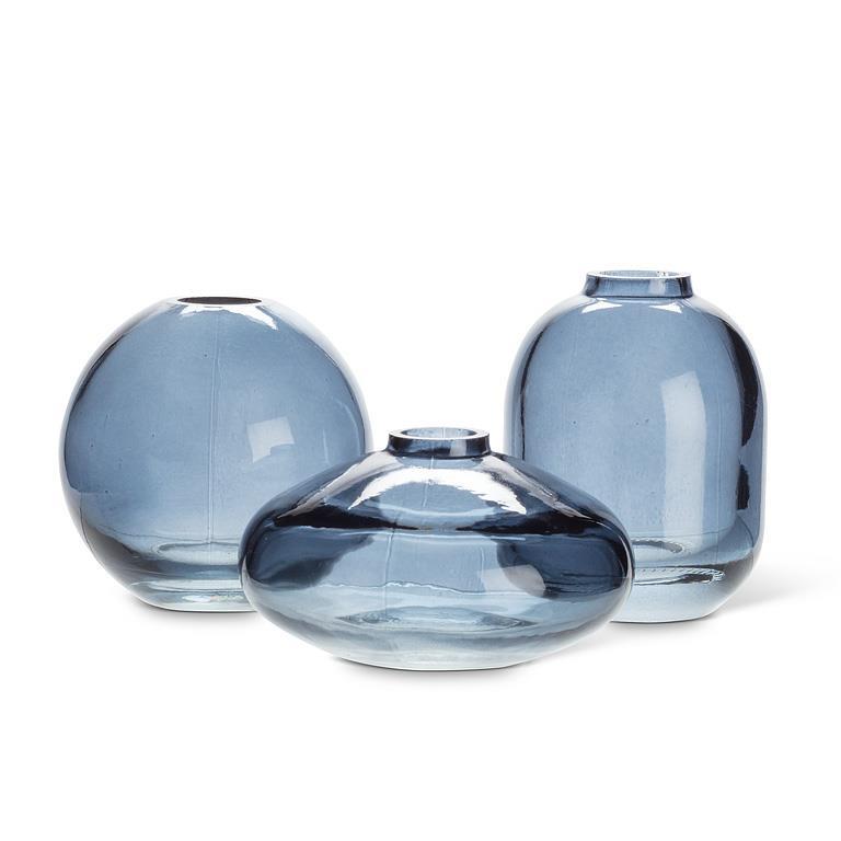Three blue glass vases of different shapes on a white background