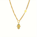Gold necklace with a small hamsa pendant on a white background