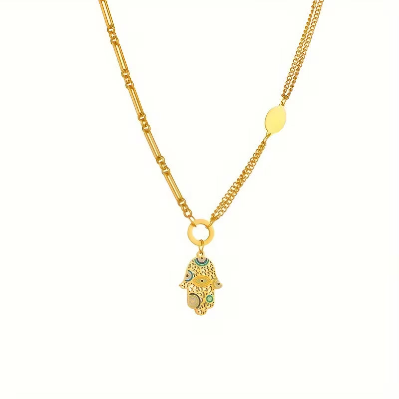 Gold necklace with a small hamsa pendant on a white background