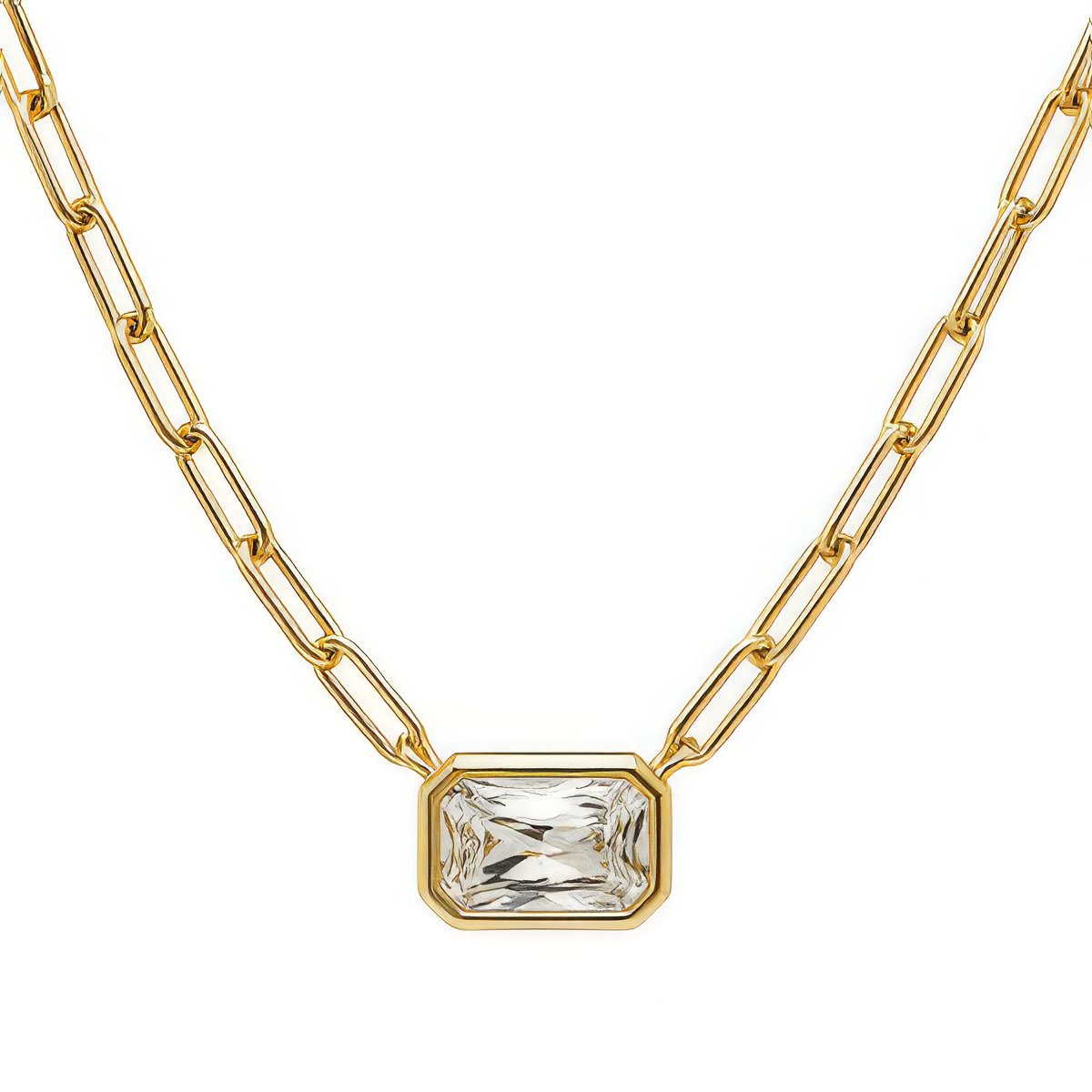 A gold paperclip chain necklace with a rectangular bezel-set clear gemstone pendant, shown against a plain white background.