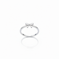 Silver ring with a bow design on a person's finger against a white background