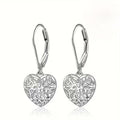 Pair of silver heart-shaped earrings with intricate designs on a white background