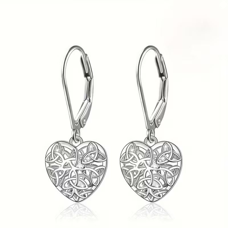 Pair of silver heart-shaped earrings with intricate designs on a white background