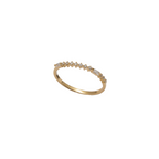 A delicate yellow gold ring featuring a row of small, clear baguette-cut gemstones set along the top band, photographed against a solid white background.