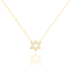 A delicate gold chain necklace featuring a Star of David pendant paved with small clear stones, displayed against a clean white background with a soft reflection below.