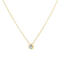 A delicate yellow gold chain necklace with a small round bezel-set clear gemstone pendant, shown against a plain white background.