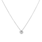 A delicate silver chain necklace with a small round bezel-set clear gemstone pendant, displayed against a solid white background.