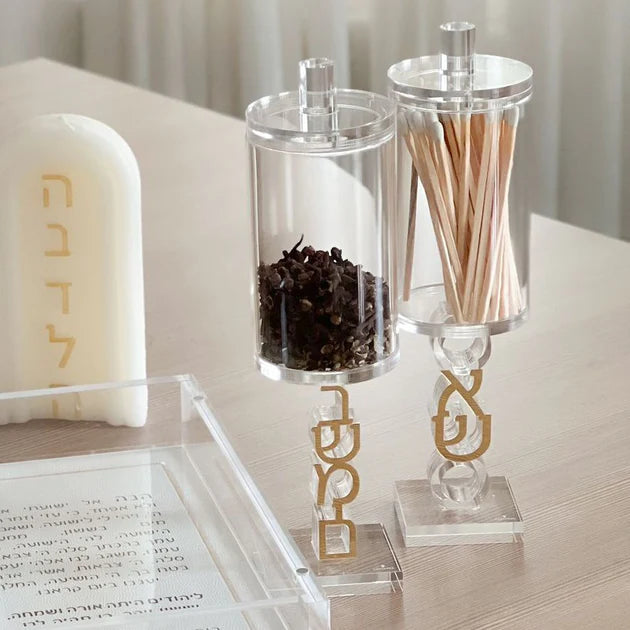 Clear containers with gold lettering on a wooden surface