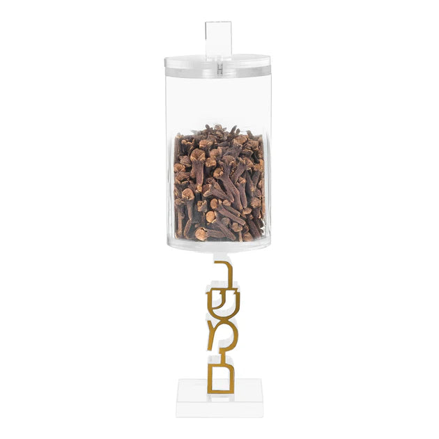 Clear hanging container with cloves and gold hook on a white background