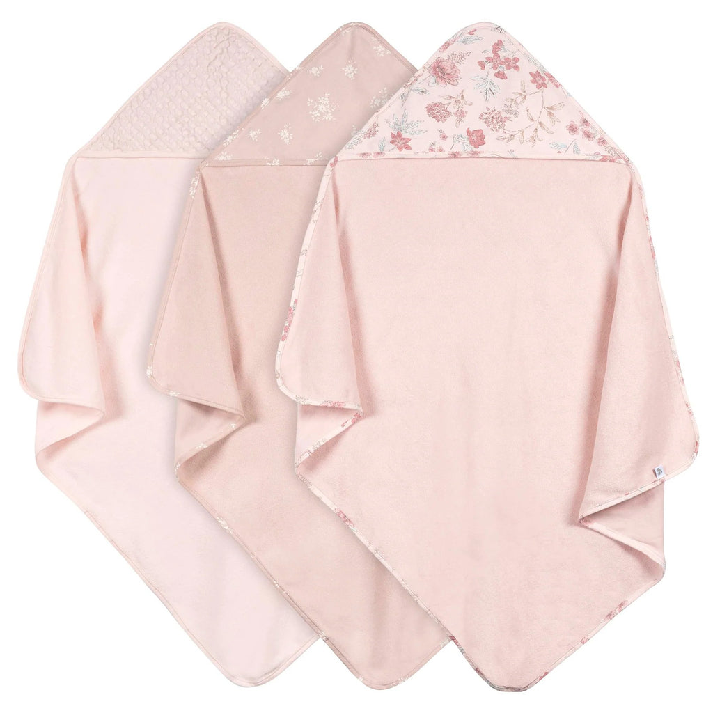 Three pink hooded towels with floral patterns on a white background