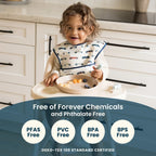 Child in a kitchen wearing a bib with food on a tray, surrounded by text about chemical free products.
