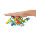 Colorful toy with various textures held by a hand on a white background