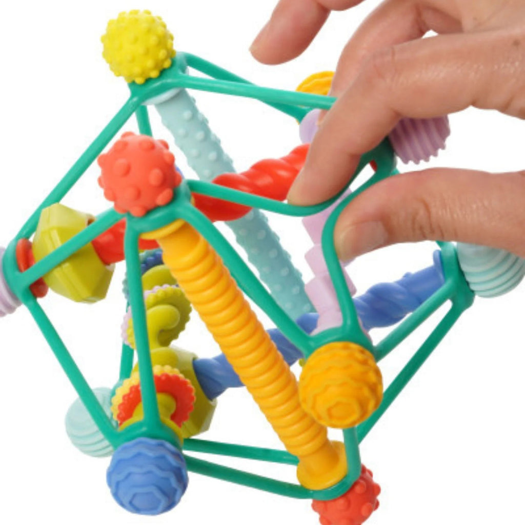 Colorful geometric toy with a hand interacting with it on a white background