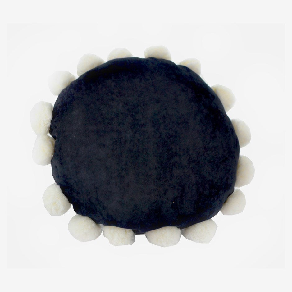 Round black pillow with white spherical elements on a white background